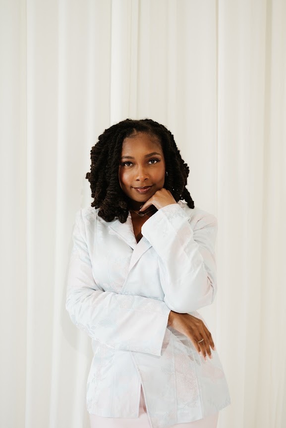 Editorial portrait of the founder of The ROI Report in a white blazer against a soft cream backdrop